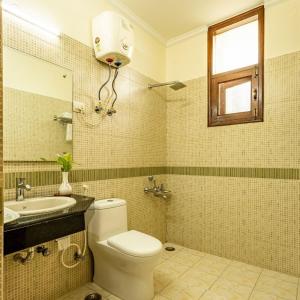 a bathroom with a toilet and a sink and a mirror at Theap Hospitality Enterprises in Noida