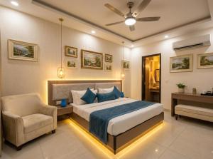 a bedroom with a bed and a chair and a ceiling fan at Sky Nest Plaza Inns Near Delhi International Airport in New Delhi
