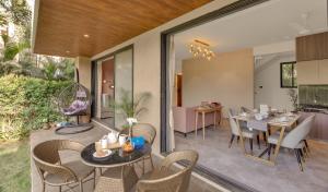 a patio with a table and chairs and a kitchen at Saffron Stays Augustus in Karjat