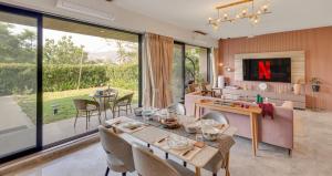 a kitchen and dining room with a table and chairs at Saffron Stays Augustus in Karjat