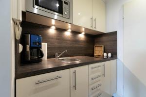 a kitchen with a sink and a microwave at Top gelegene Ferienwohnung mit Balkon direkt im Zentrum von SPO in Böhl