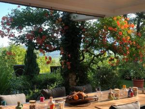 a table in a garden with a tree with flowers at Villa Aux Chênaies in Obernai