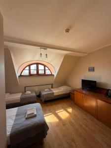 a large room with two beds and a window at Hotel City in Gniezno