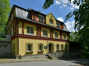 a large yellow house with stairs in front of it at Spa Resort Libverda - Hotel Lesní Zátiší in Lázně Libverda