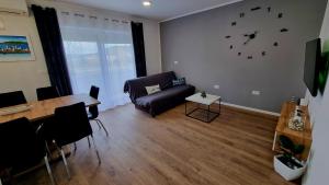 a living room with a couch and a clock on the wall at Apartments Josip 2830 in Rab