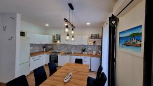 a kitchen with a wooden table and chairs in it at Apartments Josip 2830 in Rab