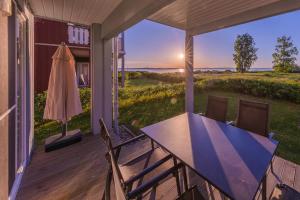 a porch with a table and chairs and a view of the ocean at Gartendeck 531 in Rechlin