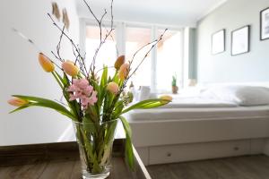 a vase of flowers sitting on a table in a bedroom at Top gelegene Ferienwohnung mit Balkon direkt im Zentrum von SPO in Böhl