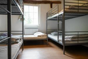 a room with three bunk beds and a window at San Sebastian Surf and Party Hostel in Aia