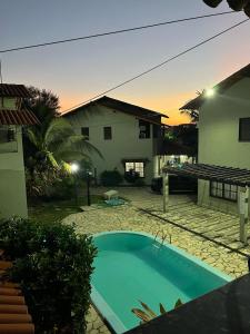 a swimming pool in front of a house at CASA de 02 suítes e 1 quarto, piscina e churrasqueira "casa maré alta" in Barra de São Miguel