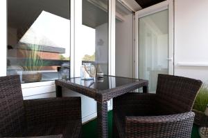 a glass table and two chairs on a balcony at Top gelegene Ferienwohnung mit Balkon direkt im Zentrum von SPO in Böhl +8 photos