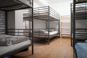 a room with three bunk beds in a room at San Sebastian Surf and Party Hostel in Aia +4 photos