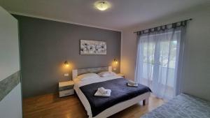 a bedroom with a bed with two towels on it at Apartments Josip 2830 in Rab
