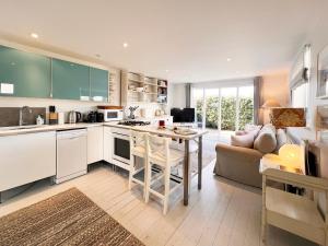 a kitchen and living room with a couch and a table at Spinney's Boathouse by The Suffolk Cottage Collection in Thorpeness