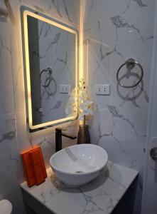 a bathroom with a white sink and a mirror at JAL Transient House in Hinoba-an