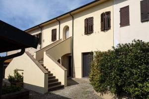 a building with a staircase leading to a garage at Podere San Michele Cantina con Camere in San Vincenzo