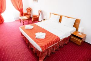 ein Hotelzimmer mit einem Bett, auf dem zwei Handtücher liegen in der Unterkunft West Gate Studios in Bukarest