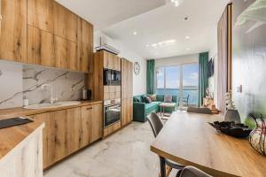a kitchen and living room with a table and a couch at The Butterfly Apartment | Seafront & Amazing Views by PikHost in Lezhë