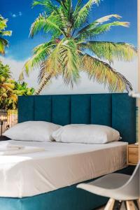 a bedroom with a bed with a palm tree in the background at The Butterfly Apartment | Seafront & Amazing Views by PikHost in Lezhë