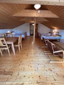 ein Raum mit Tischen und Stühlen und einem Holzboden in der Unterkunft Kloster Gård - Cabins & apartments near Astrid Lindgrens World in Hultsfred
