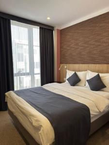 a bedroom with a large bed with a large window at Graf Hotel in Shymkent +38 photos