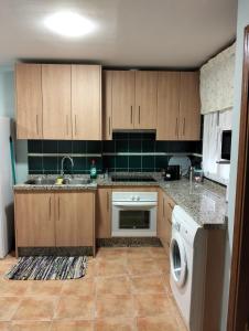 a kitchen with wooden cabinets and a washing machine at Modern Flat in Guejar Sierra in Güéjar-Sierra
