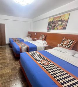 a group of three beds in a room at Depamia in Huaraz