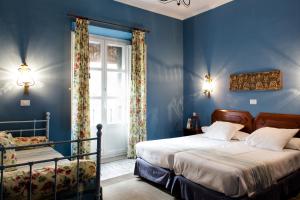a blue bedroom with two beds and a window at Hotel Abanico in Seville