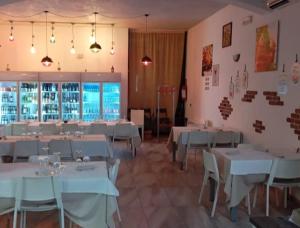 a dining room with white tables and chairs at Hotel-Ristorante KerMes in Boccaleone