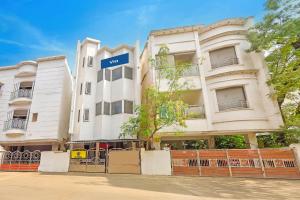 a white building with a blue sign on it at Via KR in Chennai