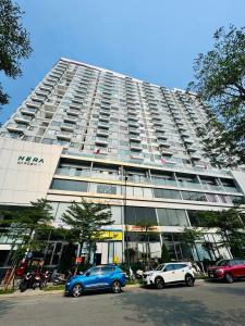 a large building with cars parked in front of it at AC Nera Garden Apartment in Thôn Văn Dương