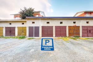 a parking area sign in front of a garage at [Soleado] Il primo caffè con il sole da 3 lati in Acqui Terme
