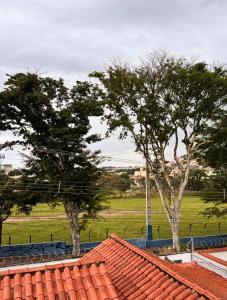 two trees in a field with red roofs at STUDIO Flat B in Betim