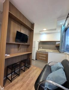 a living room with a couch and a television at STUDIO Flat B in Betim