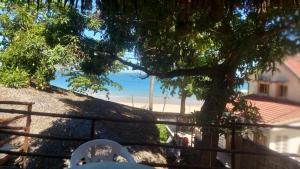 two white chairs sitting on a fence with a tree at Bungalow Soa Majunga in Mahajanga