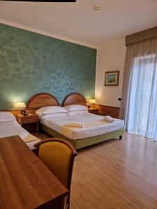 a hotel room with two beds and a table at Hotel L'Aquila in Pomezia +20 photos