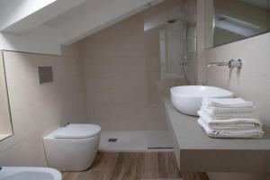 a white bathroom with a sink and a toilet at Villa Serena - Armonia Apartment in Tirrenia