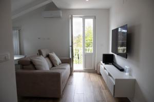 a living room with a couch and a tv at Villa Serena - Armonia Apartment in Tirrenia +4 photos