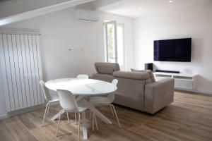 a living room with a white table and a couch at Villa Serena - Armonia Apartment in Tirrenia