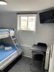 a small room with a bunk bed and a desk at Alma House in Dover
