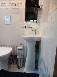 a bathroom with a white sink and a toilet at Gozo Duplex Studio overlooking historic Piazza in Victoria +8 photos