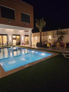 a swimming pool in front of a house at night at Ranachalet-1 in Ash Shāghūr
