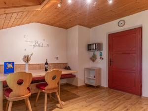 a room with a red door and a table and chairs at Wieshof in Kaltenbach