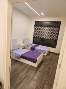 a bedroom with two beds and a large window at Ranachalet-1 in Ash Shāghūr +19 photos