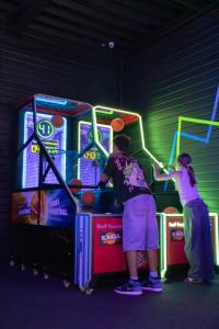 two people playing a video game on a pinball machine at Paxton Paris MLV in Ferrières-en-Brie