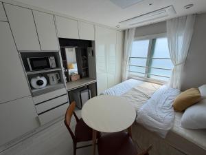 a small bedroom with a bed and a table at 여유스테이 in Suwŏn-yŏk