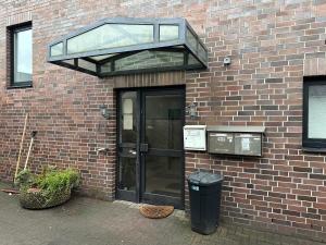 a glass door on a brick building with a trash can at Boberger Hostel in Hamburg +8 photos