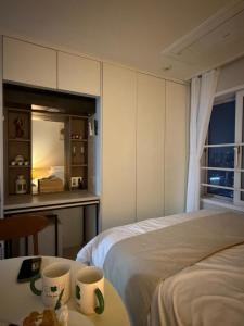 a bedroom with a bed and a table with cups on it at 여유스테이 in Suwŏn-yŏk