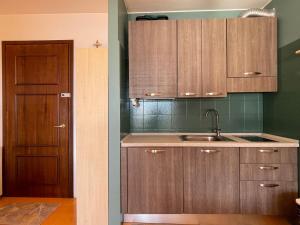 a kitchen with wooden cabinets and a sink and a door at Appartamento Pascià al Lago in Oggebio