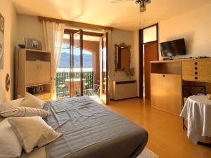 a bedroom with a large bed and a balcony at Appartamento Pascià al Lago in Oggebio